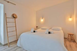 a bedroom with a large white bed with towels on it at Longe 17 - élégante propriété avec deux maisons in Longeville-sur-Mer