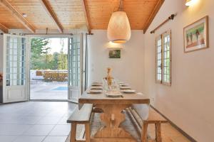 a dining room with a wooden table and a glass door at Longe 17 - élégante propriété avec deux maisons in Longeville-sur-Mer