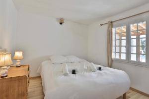 a white bedroom with two beds and a window at Longe 17 - élégante propriété avec deux maisons in Longeville-sur-Mer