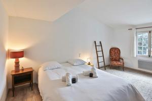 a bedroom with a large white bed with towels on it at Longe 17 - élégante propriété avec deux maisons in Longeville-sur-Mer +15 photos