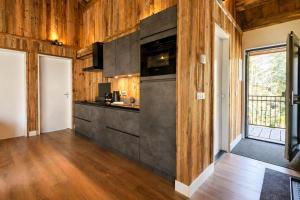 a kitchen with wooden walls and wooden flooring at Stylish Loft Apartment with Mountain View near the Lake in Afritz