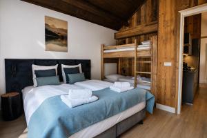 a bedroom with two beds and a bunk bed at Stylish Loft Apartment with Mountain View near the Lake in Afritz
