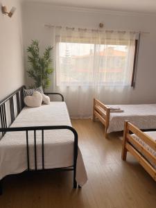 a bedroom with two beds and a window at Carminho beach house in Vila do Conde
