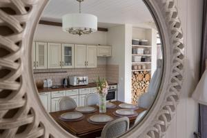 a kitchen with a table with chairs and a mirror at Lillium in Merķeļi