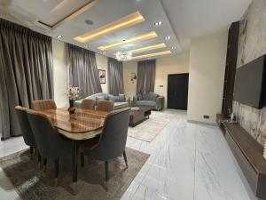 a living room with a wooden table and a couch at Tombell Homes in Ibadan