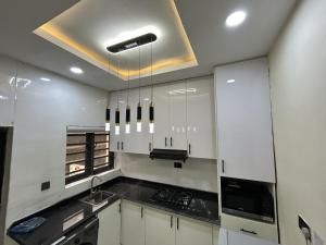 a kitchen with white cabinets and a ceiling at Tombell Homes in Ibadan +17 photos