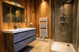 a bathroom with a sink and a shower at Stylish Loft Apartment with Mountain View near the Lake in Afritz +36 photos
