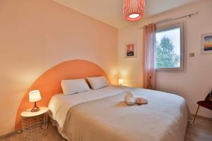 a bedroom with a bed with a teddy bear on it at Quai Ouest - élégante maison avec piscine in Saint-Vincent-sur-Jard