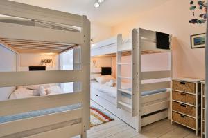two bunk beds in a room with a tv at Quai Ouest - élégante maison avec piscine in Saint-Vincent-sur-Jard