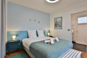 a bedroom with a large bed with two pillows at Quai Ouest - élégante maison avec piscine in Saint-Vincent-sur-Jard