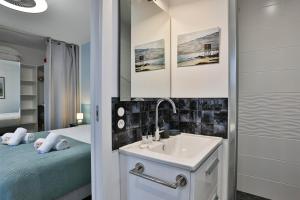 a bathroom with a sink and a bed at Quai Ouest - élégante maison avec piscine in Saint-Vincent-sur-Jard +8 photos