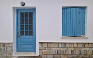 a blue door and a window on a building at BlePelagos house in Glossa