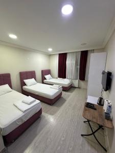 a hotel room with two beds and a flat screen tv at İnci Otel in Duzce