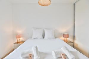 a bedroom with a white bed with two lamps at La Bulle - Maison classée 4 étoiles in Brem-sur-Mer +16 photos