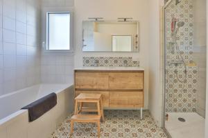 a bathroom with a tub and a sink and a mirror at La Bulle - Maison classée 4 étoiles in Brem-sur-Mer