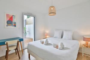 a bedroom with a white bed and a desk and a chair at La Bulle - Maison classée 4 étoiles in Brem-sur-Mer