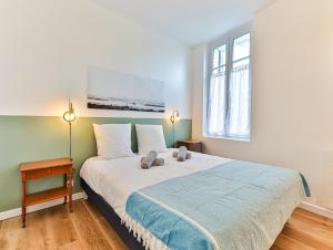 a bedroom with a large bed with two stuffed animals on it at Maison des Surfeurs in Les Sables-d'Olonne