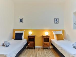 two twin beds in a room with yellow walls at Maison des Surfeurs in Les Sables-d'Olonne