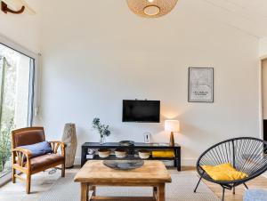 a living room with a table and a tv at Maison des Surfeurs in Les Sables-d'Olonne +13 photos