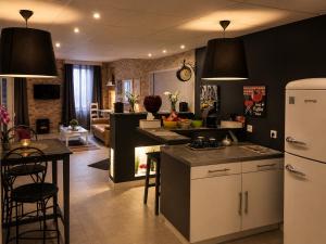 a kitchen with black walls and a kitchen with a refrigerator at Appart' Spa et Sauna Privatif Au Cœur De Beaune in Beaune