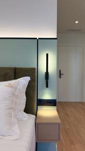 a bedroom with a white bed and a night stand at Golden Nina Hotel in Vlorë
