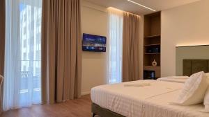 a hotel room with two beds and a tv at Golden Nina Hotel in Vlorë