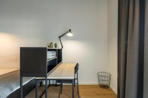 a desk with a lamp and a table with a chair at Codomo Living Carcavelos Lombos in Carcavelos +32 photos