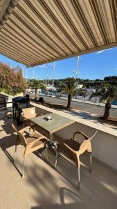 a table and chairs on a patio with a view of the water at SFE Apartment in Milna