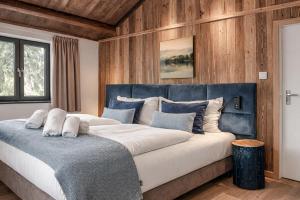 a large bed in a room with wooden walls at Stylish Loft Apartment with Mountain View near the Lake in Afritz