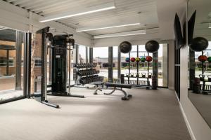 a gym with treadmills and benches and windows at The Lantern Hotel Columbia in Columbia