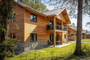 a wooden house with a metal roof at Stylish Loft Apartment with Mountain View near the Lake in Afritz