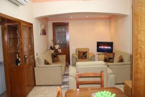 a living room with couches and a flat screen tv at Gjirokaster Mountain View Apartment in Gjirokastër
