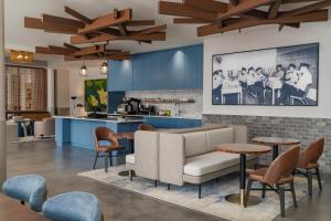 a living room with a couch and tables and a kitchen at The Lantern Hotel Columbia in Columbia