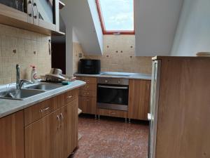 a kitchen with a sink and a stove and a window at Guest Zimmer Nora in Zamárdi