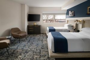 a hotel room with two beds and a television at The Lantern Hotel Columbia in Columbia