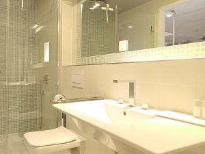 a bathroom with a sink and a toilet and a mirror at NOX HOTEL - Digital-Check-In - No Reception - nahe Bretten & Karlsruhe - 6 Beach in Wössingen