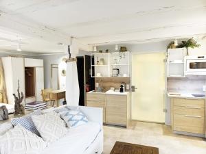 a living room with a white couch and a kitchen at NOX HOTEL - Digital-Check-In - No Reception - nahe Bretten & Karlsruhe - 6 Beach in Wössingen