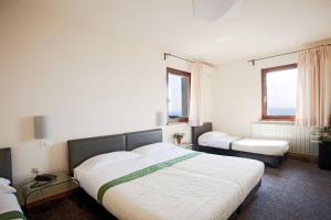 a bedroom with two beds and two windows at Casa Oliva borgo del Benessere delle Marche in Bargni