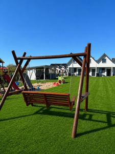 a playground with a swing in a yard at Domek Ga-Ba in Sarbinowo