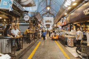 a group of people walking through a market at The J Luxury Apartments Near Mahane Yehuda - Perfect for Shabbat Stays in Jerusalem