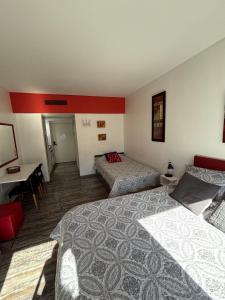 a hotel room with two beds and a desk at Departamento en Microcentro (Obelisco) in Buenos Aires