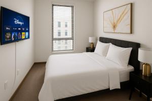 a bedroom with a large white bed and a window at Five Points South Spacious 2BR with 2 Queens D5 in Birmingham