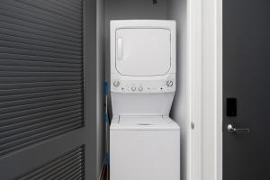 a washer and dryer sitting on top of a refrigerator at Five Points South Spacious 2BR with 2 Queens D5 in Birmingham