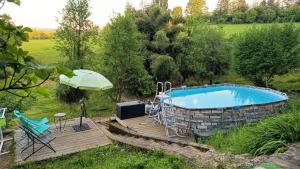 a swimming pool in a yard with a deck and a table and chairs at La Fontaine du Mas in Thiviers