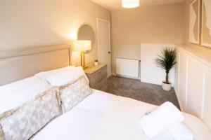 a bedroom with a white bed and a potted plant at Modern 2-Bed Apartment, Greenock in Greenock
