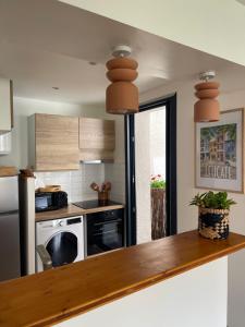 a kitchen with a wooden counter top and appliances at La Clef de la Place in Leucate