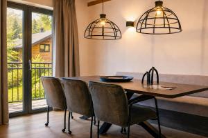 a dining room with a table and chairs and windows at Stylish Loft Apartment with Mountain View near the Lake in Afritz