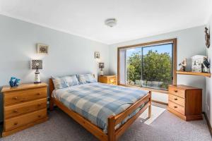a bedroom with a bed and a large window at Spikes Place - Waterfront Serenity for Groups in Hindmarsh Island
