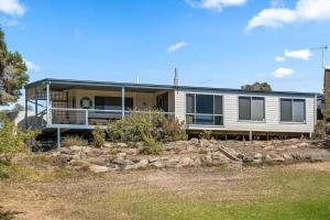 a house on a hill with a yard at Spikes Place - Waterfront Serenity for Groups in Hindmarsh Island