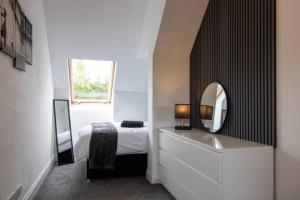 a bedroom with a bed and a sink and a mirror at Spacious 3-Bed Apartment, Alva, Clackmannanshire in Alva